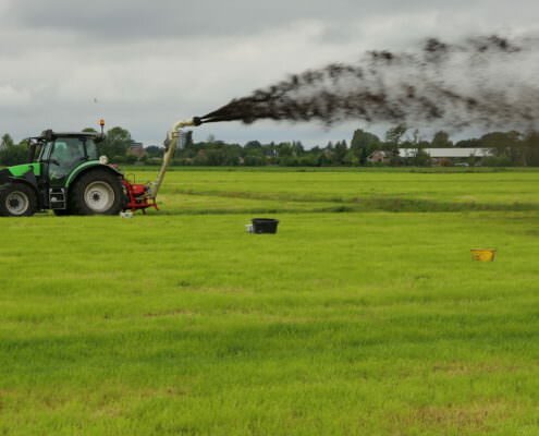 Spuiten van bagger over veenweidengebied in Proeftuin Veenweiden